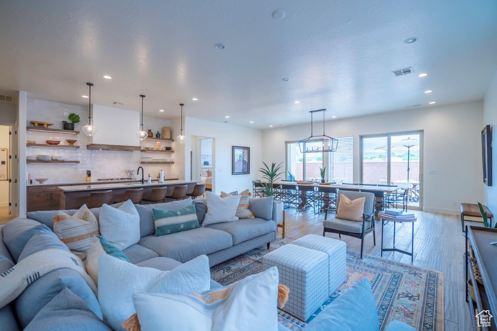 Living room with recessed lighting, light wood-type flooring, and baseboards