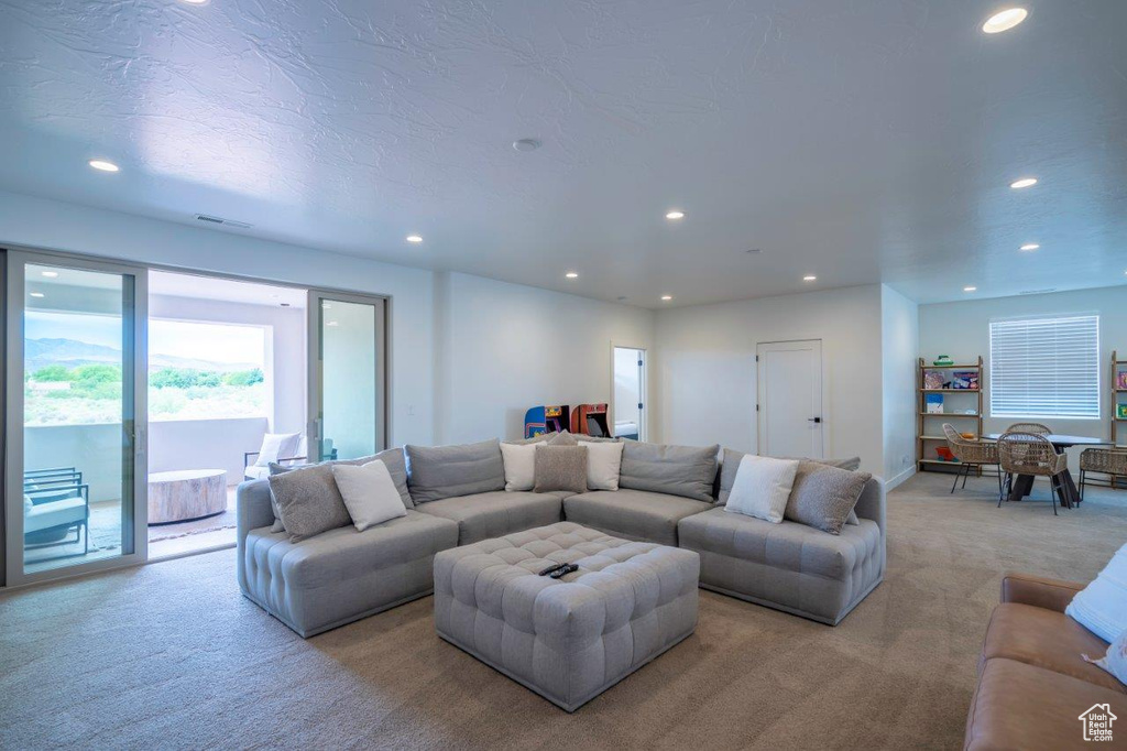 Living area featuring light colored carpet, recessed lighting, and baseboards