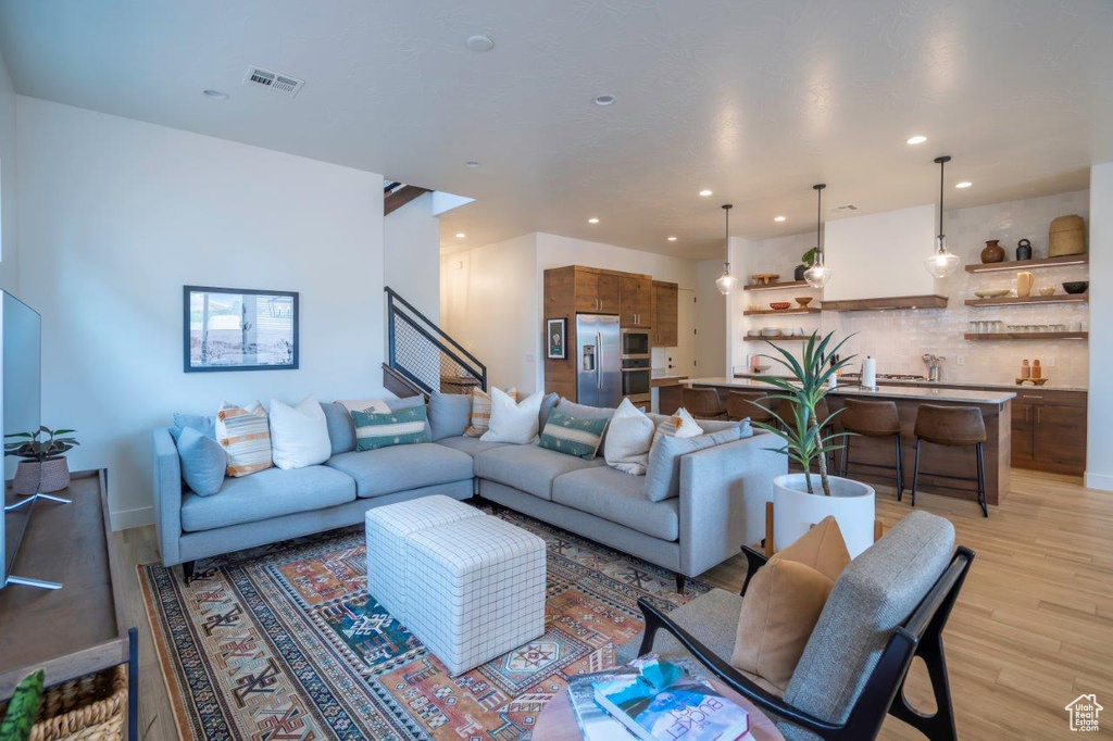 Living room featuring light wood-type flooring, stairway, and recessed lighting