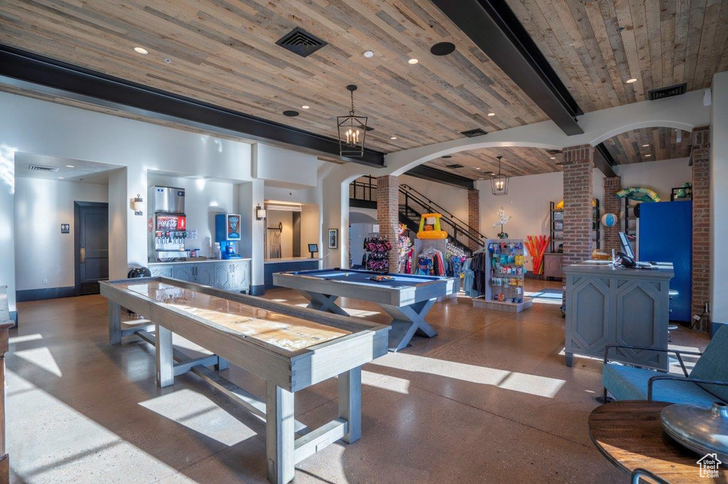Rec room featuring decorative columns, arched walkways, wooden ceiling with exposed beams, pool table, and baseboards