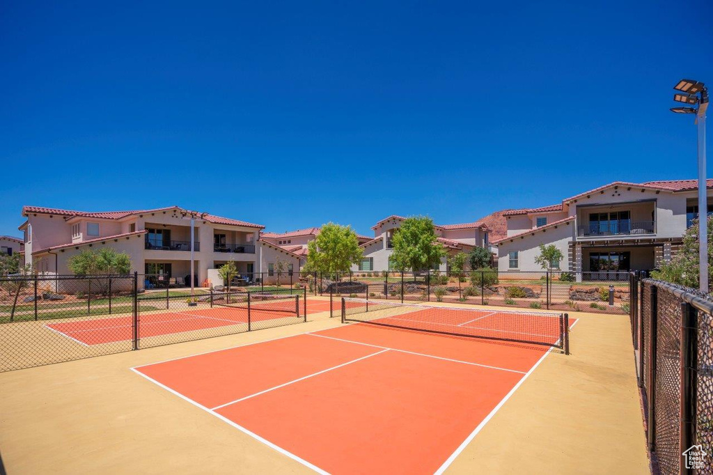 View of tennis court featuring community basketball court and a residential view