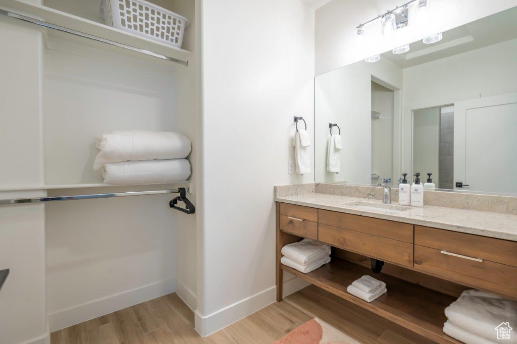 Bathroom featuring wood finished floors, vanity, and baseboards