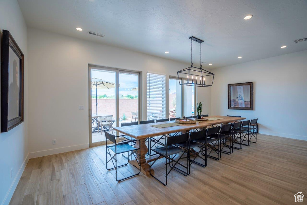 Dining space featuring light wood-style flooring, baseboards, recessed lighting, and a chandelier