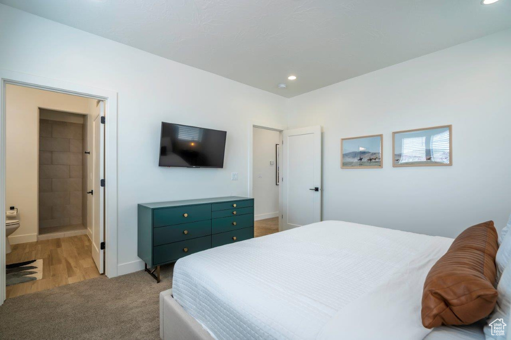 Bedroom with baseboards, recessed lighting, light carpet, and connected bathroom