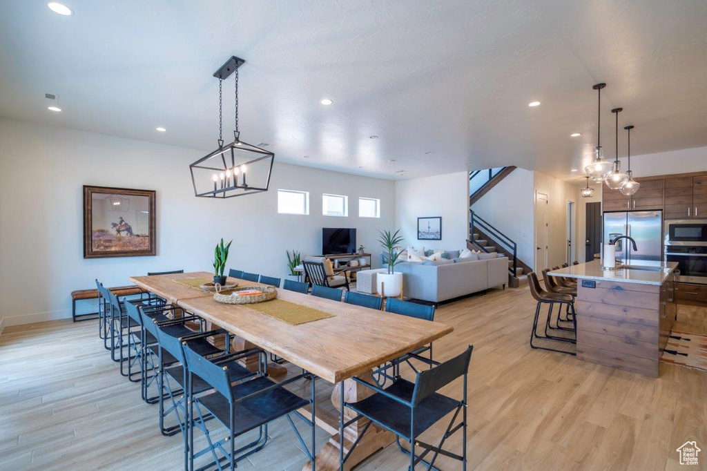 Dining area featuring recessed lighting, light wood-style flooring, stairway, and baseboards