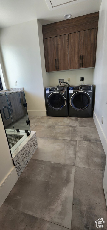 Laundry room featuring cabinet space, washing machine and dryer, and baseboards
