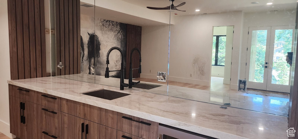 Kitchen with a sink, french doors, ceiling fan, light stone countertops, and recessed lighting