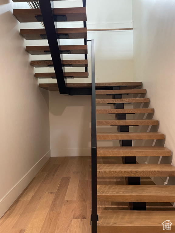 Staircase featuring wood finished floors and baseboards