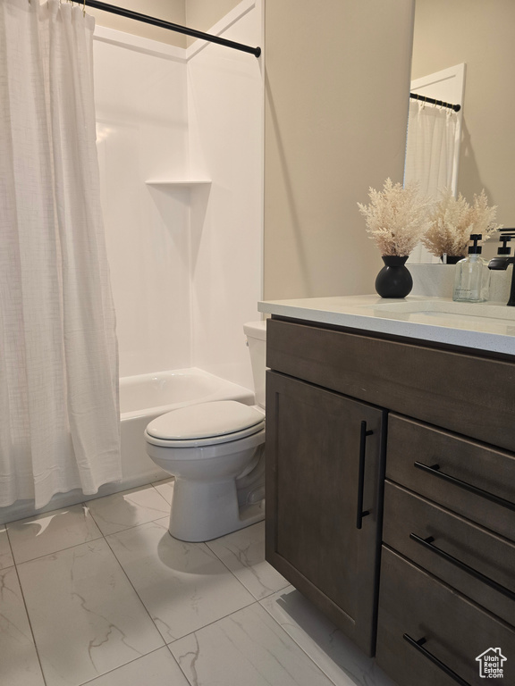 Full bathroom featuring vanity, toilet, shower / bath combination with curtain, and marble look tiles