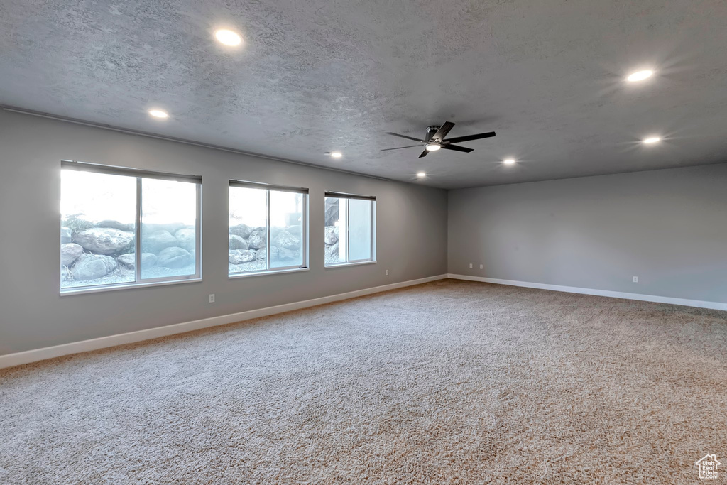 Carpeted spare room featuring recessed lighting, ceiling fan, baseboards, and a textured ceiling