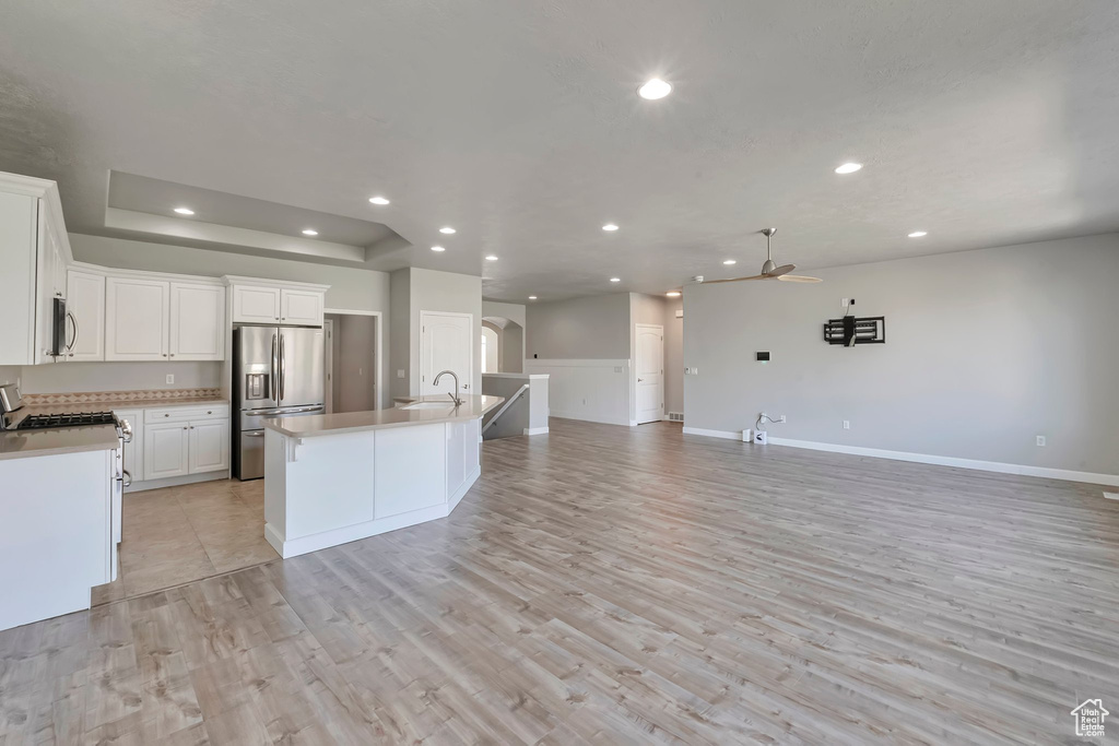 Kitchen featuring appliances with stainless steel finishes, open floor plan, a ceiling fan, a sink, and recessed lighting