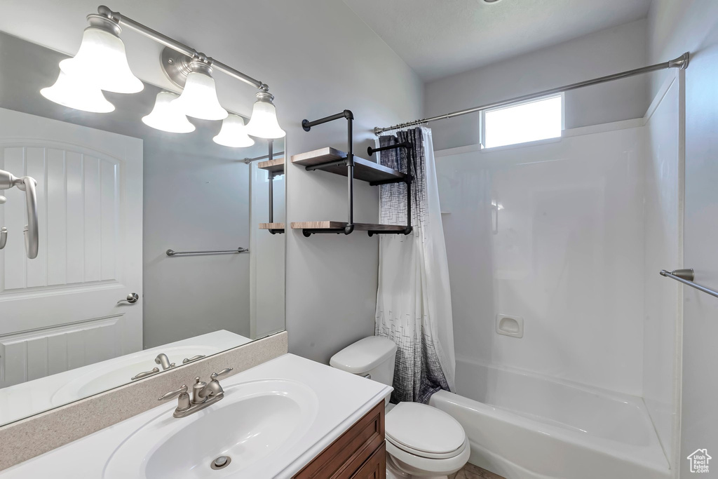 Bathroom with toilet, vanity, and shower / bath combo