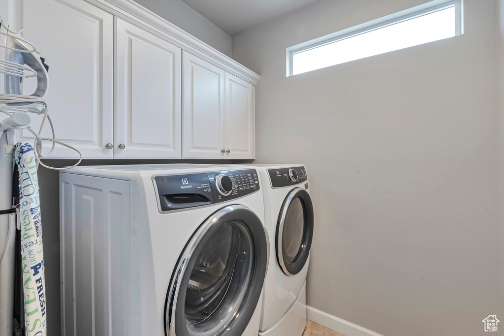 Laundry room featuring cabinet space, washer and dryer, and baseboards