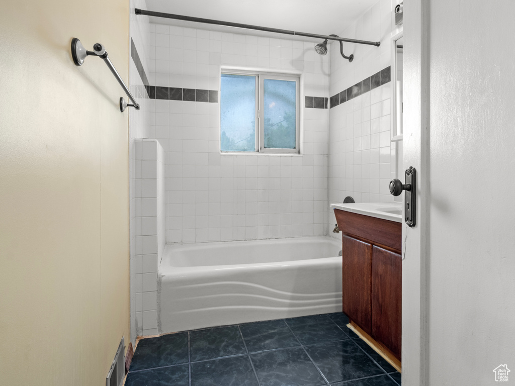 Full bath with tile patterned flooring, washtub / shower combination, and vanity