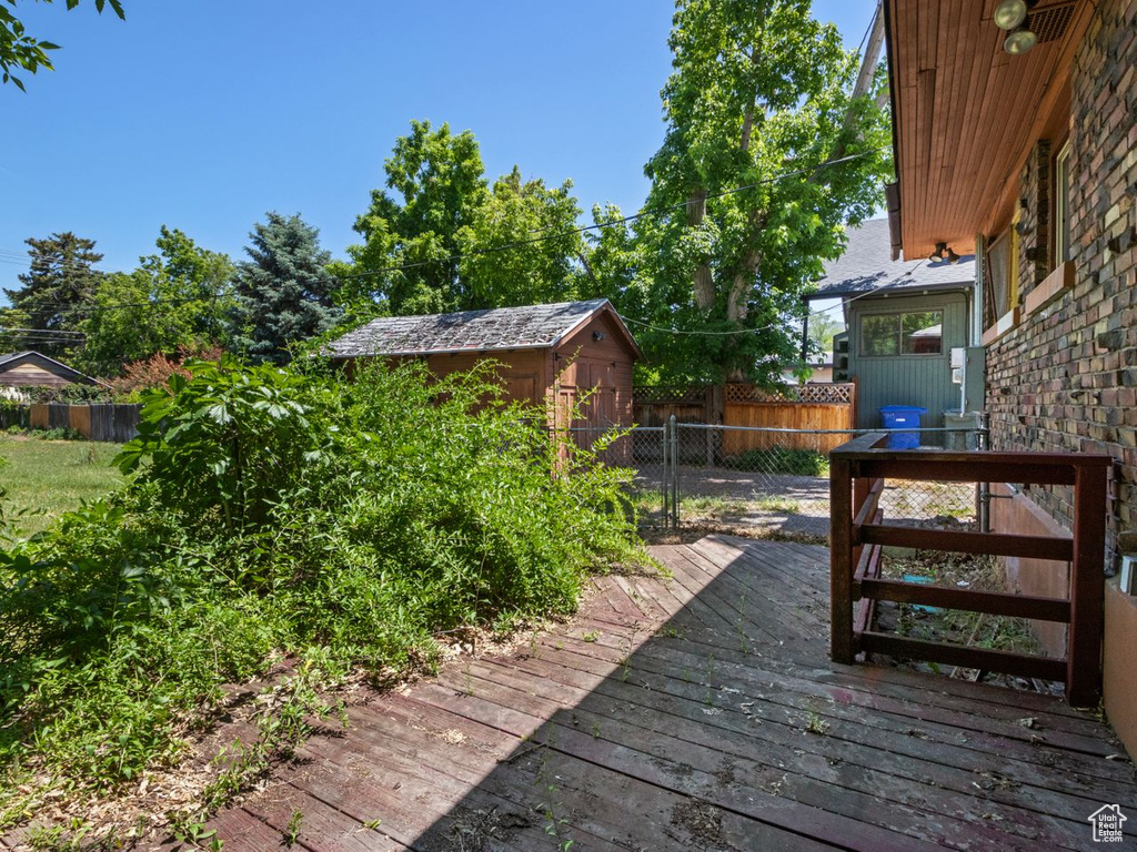 Wooden terrace with a fenced backyard
