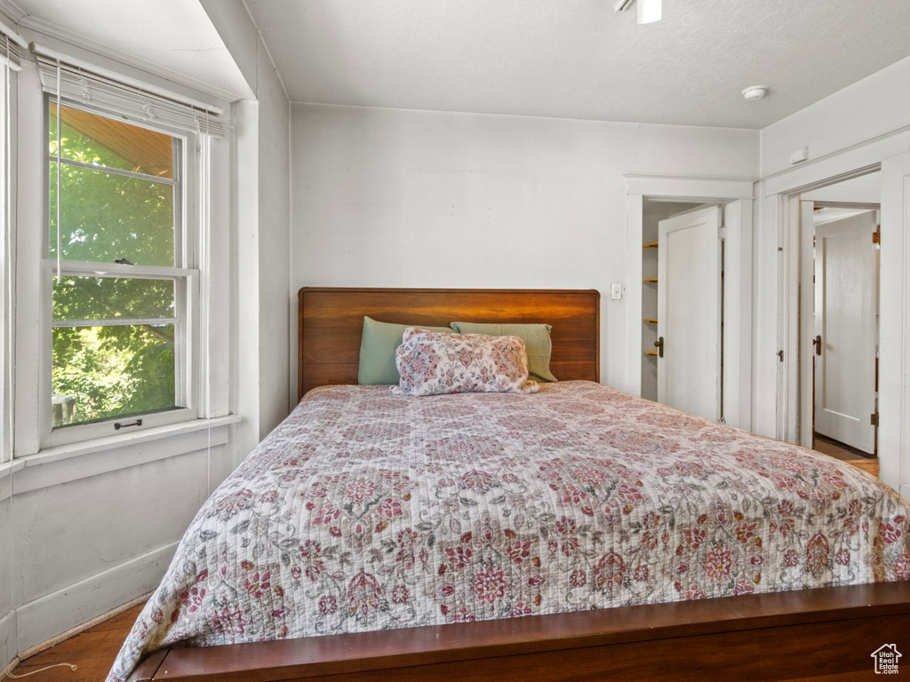 Bedroom with wood finished floors and baseboards