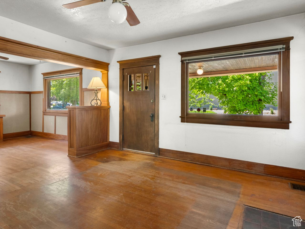 Foyer entrance featuring a ceiling fan, wood finished floors, and baseboards