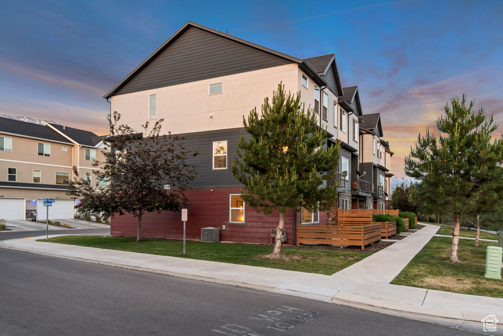 View of home's exterior with central AC unit and a yard
