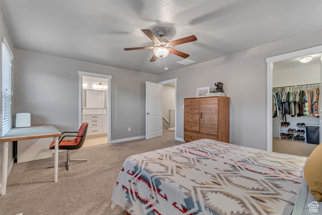 Bedroom with carpet flooring, a walk in closet, a closet, a ceiling fan, and ensuite bathroom