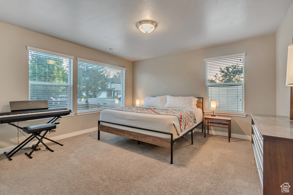 Bedroom with light colored carpet and baseboards