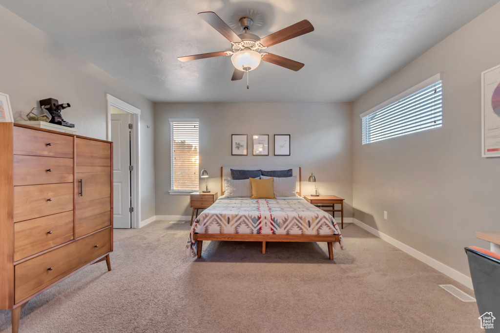 Bedroom with light carpet, baseboards, and ceiling fan