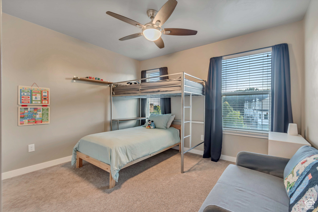 Carpeted bedroom featuring baseboards and ceiling fan