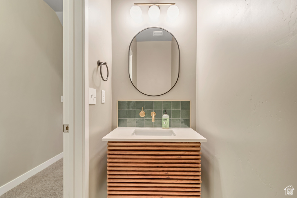 Bathroom with vanity, baseboards, and tasteful backsplash