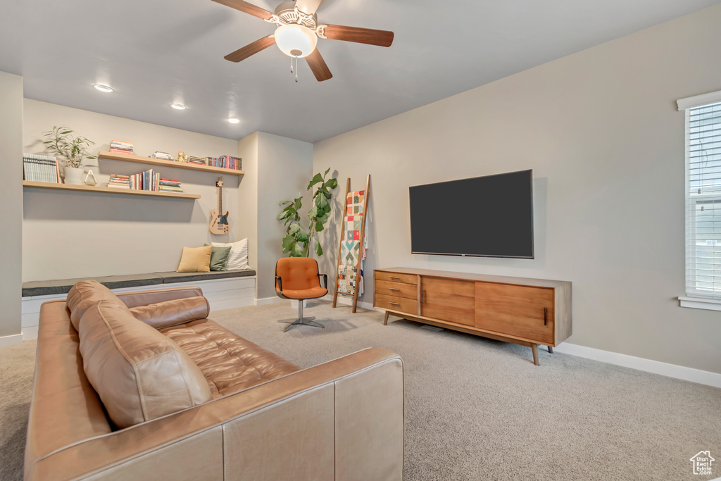 Living area featuring carpet, a ceiling fan, baseboards, and healthy amount of natural light