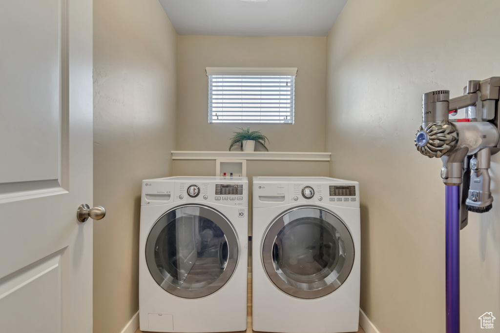 Washroom with washing machine and clothes dryer and baseboards