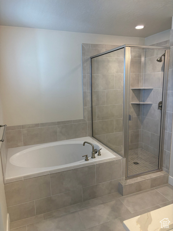 Full bath featuring a bath, a shower stall, and tile patterned flooring