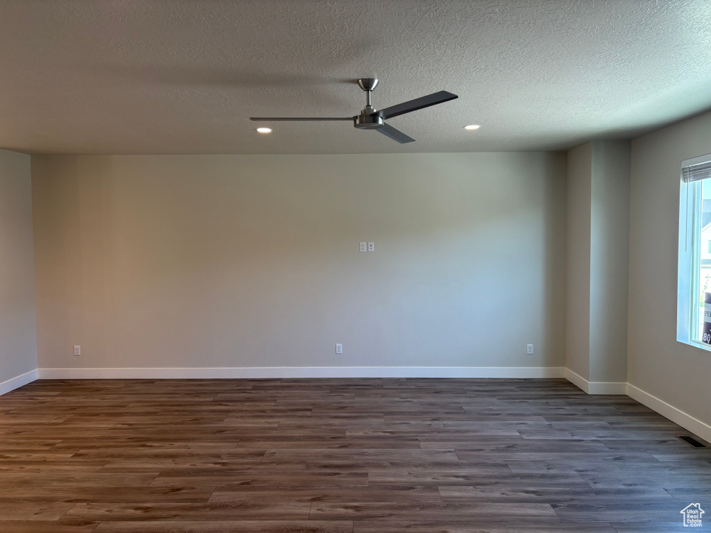 Unfurnished room with dark wood finished floors, ceiling fan, a textured ceiling, recessed lighting, and baseboards
