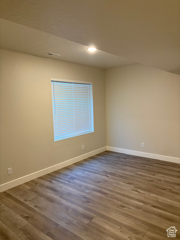 Spare room with dark wood-type flooring, baseboards, and recessed lighting