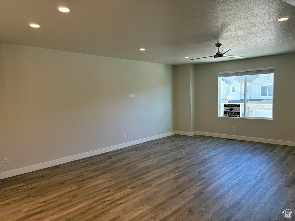 Spare room featuring dark wood-style floors, baseboards, ceiling fan, recessed lighting, and a textured ceiling