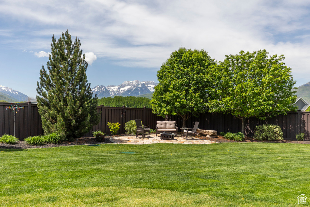 View of yard with an outdoor fire pit, a patio, and a mountain view
