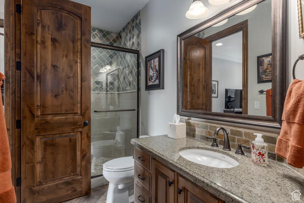 Full bath featuring vanity, a shower stall, tasteful backsplash, and toilet