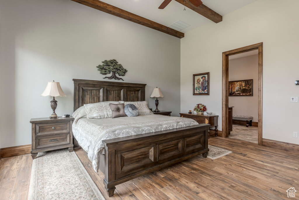 Bedroom with beam ceiling, wood finished floors, baseboards, and a ceiling fan