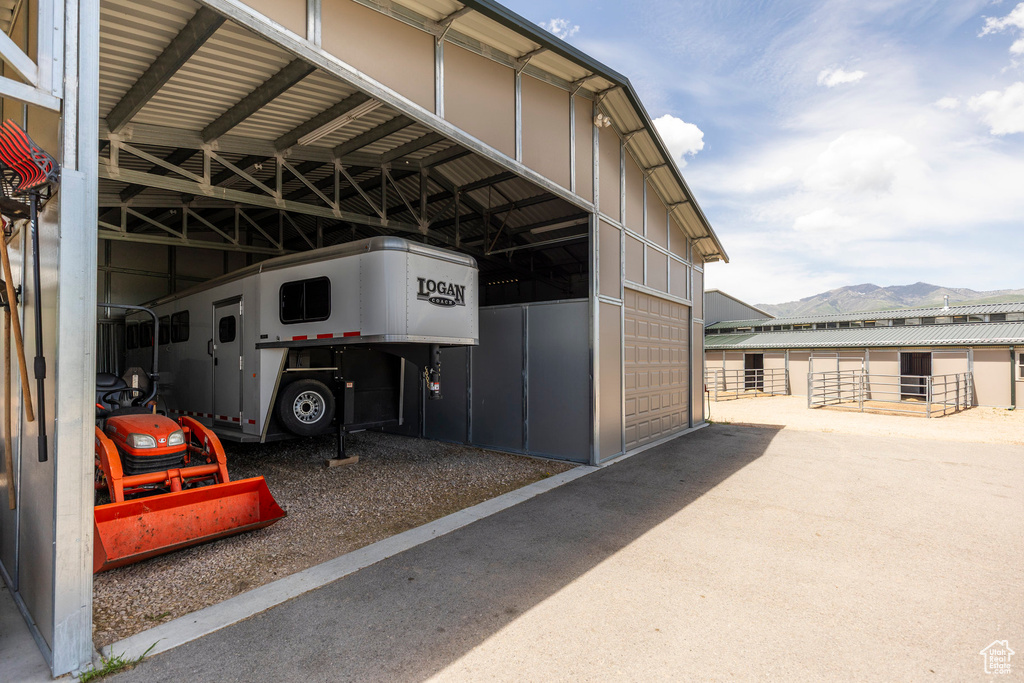 View of car parking featuring a mountain view, a garage, and a carport