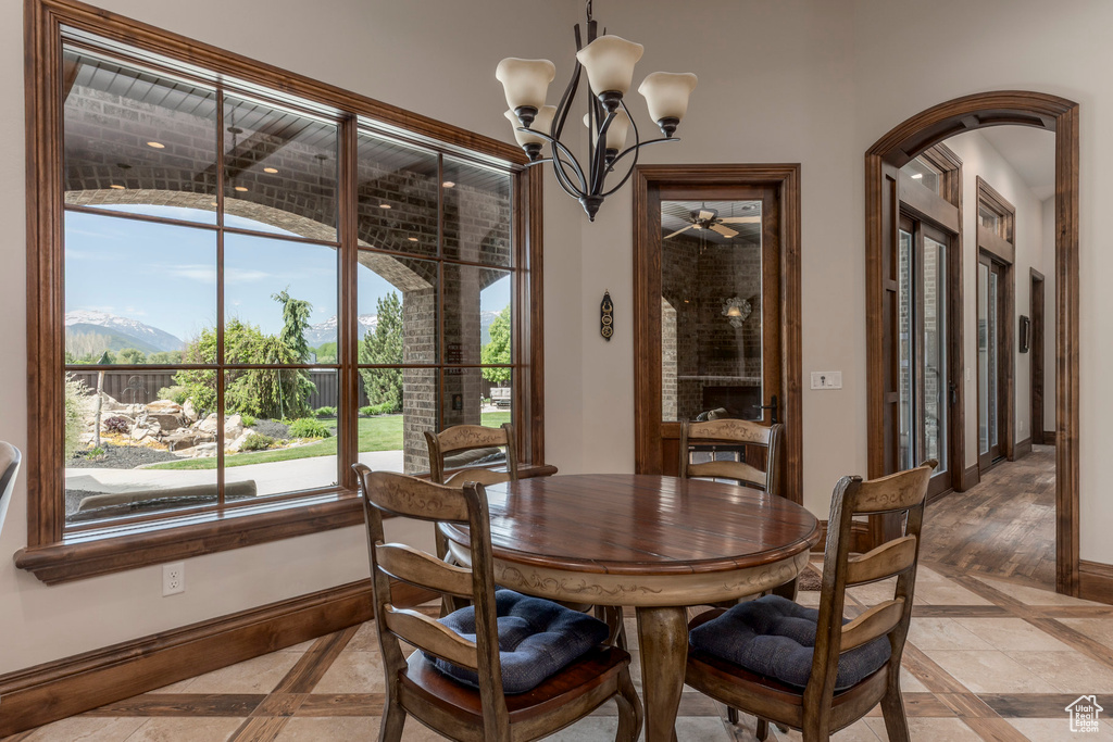 Dining room featuring inlaid floor details, baseboards, a chandelier, and ceiling fan