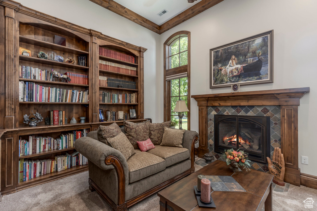 Sitting room featuring carpet flooring, a tiled fireplace, and beamed ceiling