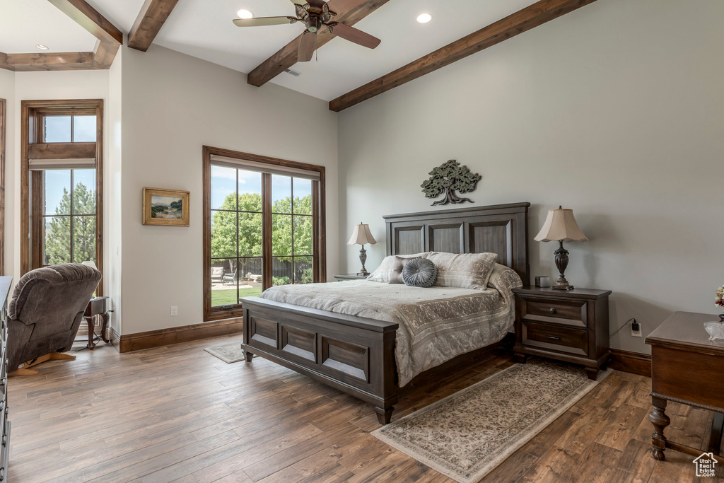 Bedroom featuring beamed ceiling, multiple windows, baseboards, hardwood / wood-style floors, and recessed lighting