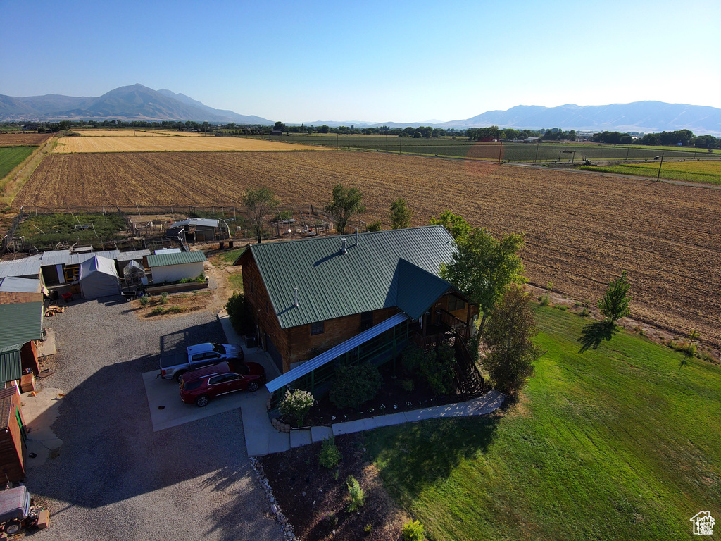 Overview of rural landscape featuring rows of crops and a mountain backdrop