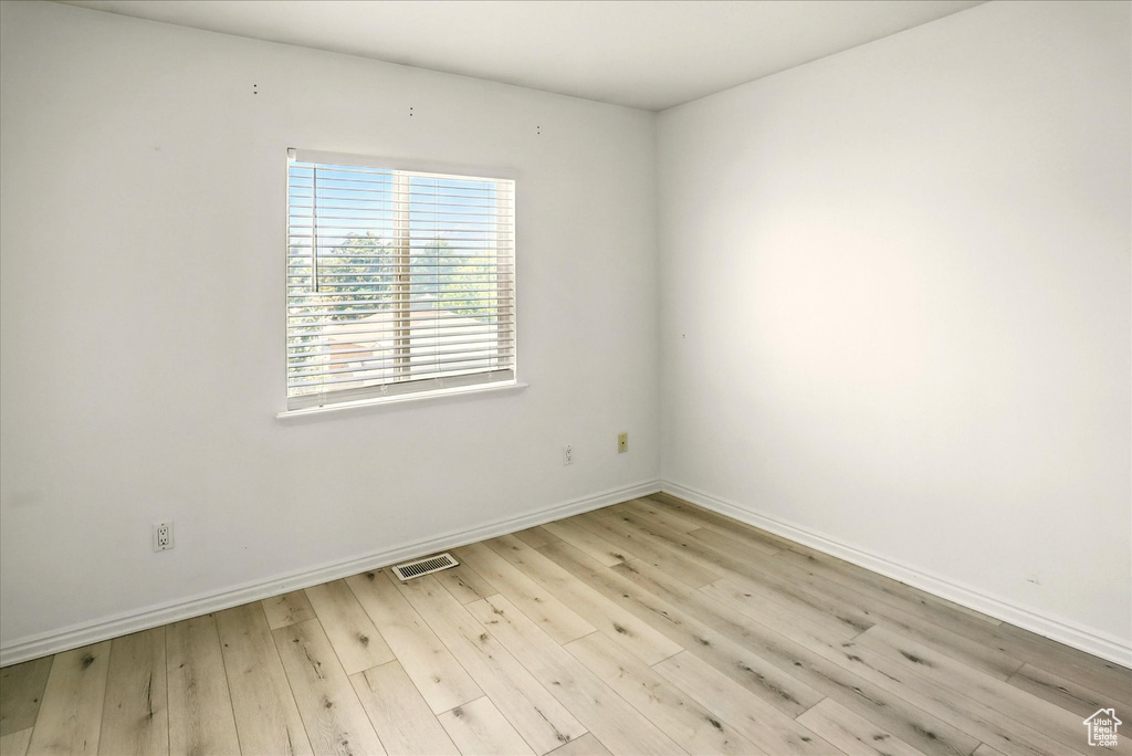 Spare room with baseboards and light wood-style floors