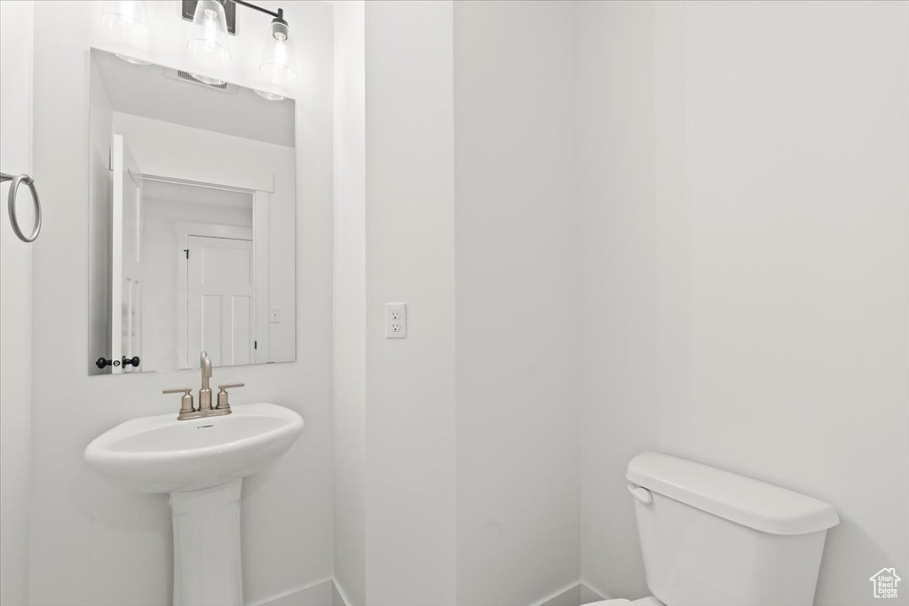 Half bathroom featuring toilet and baseboards