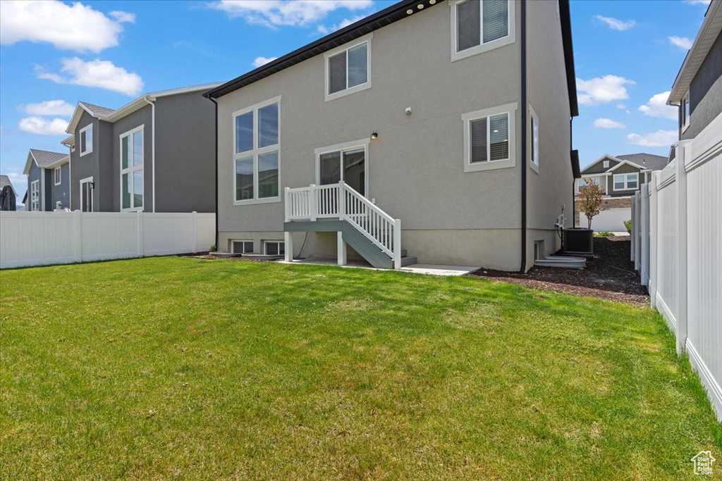 Back of property with cooling unit, stucco siding, and a residential view