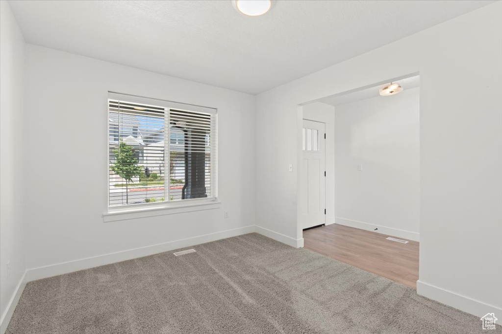 Carpeted spare room with baseboards