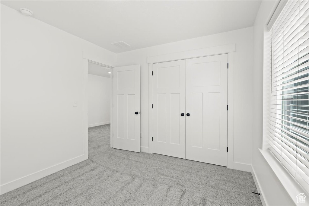 Unfurnished bedroom with carpet, baseboards, and a closet