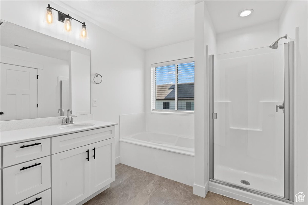 Full bathroom featuring vanity, a garden tub, and a stall shower