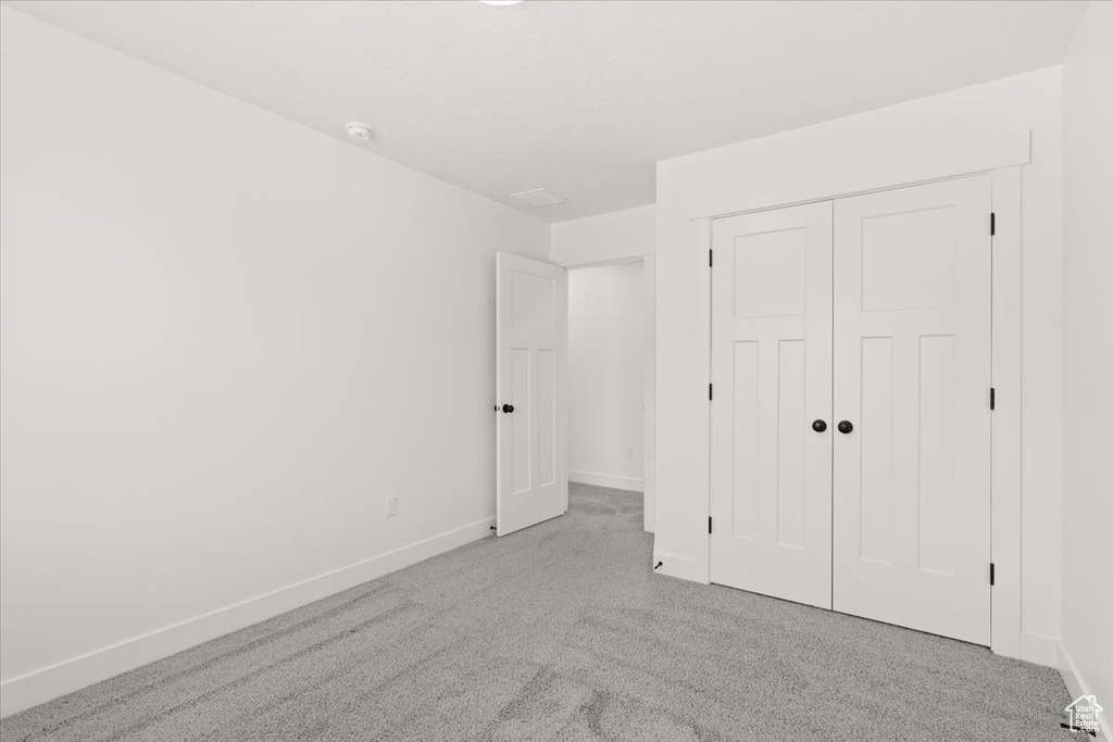 Unfurnished bedroom with carpet floors, baseboards, and a closet