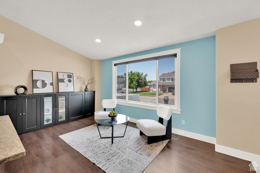 Sitting room featuring dark wood-type flooring, lofted ceiling, recessed lighting, and baseboards
