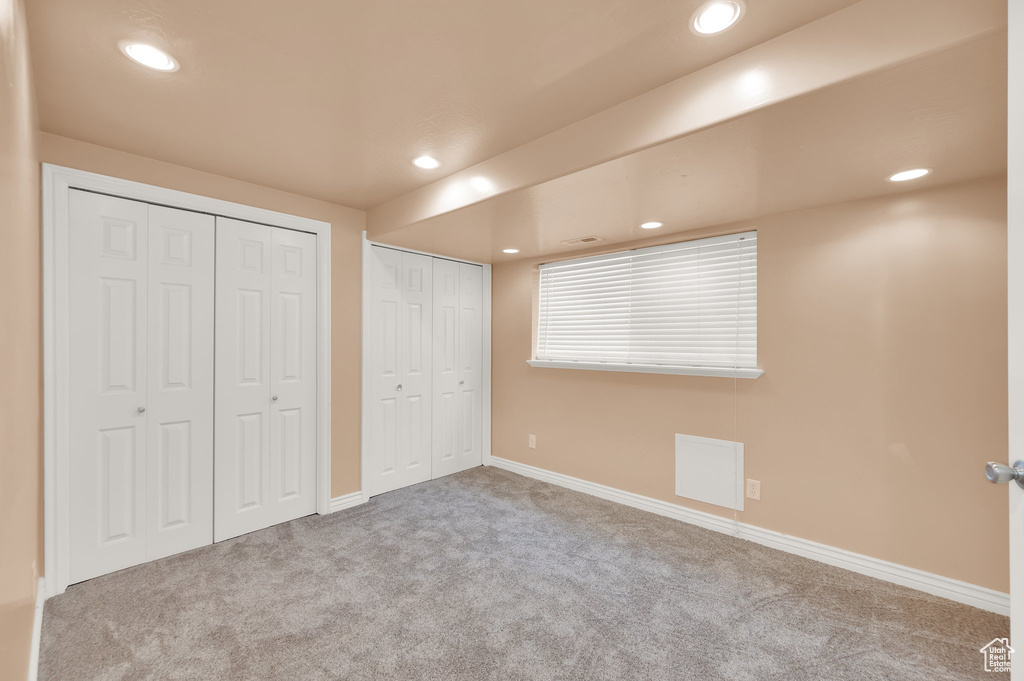 Unfurnished bedroom featuring carpet, multiple closets, recessed lighting, and baseboards